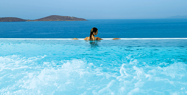 Women in an infinity pool overlooking the sea