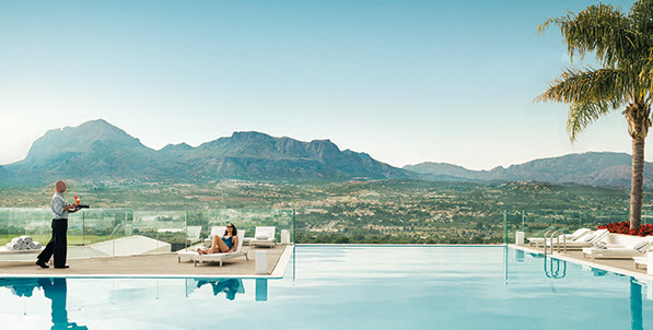 Woman relaxing by the pool at Sha Wellness Clinic