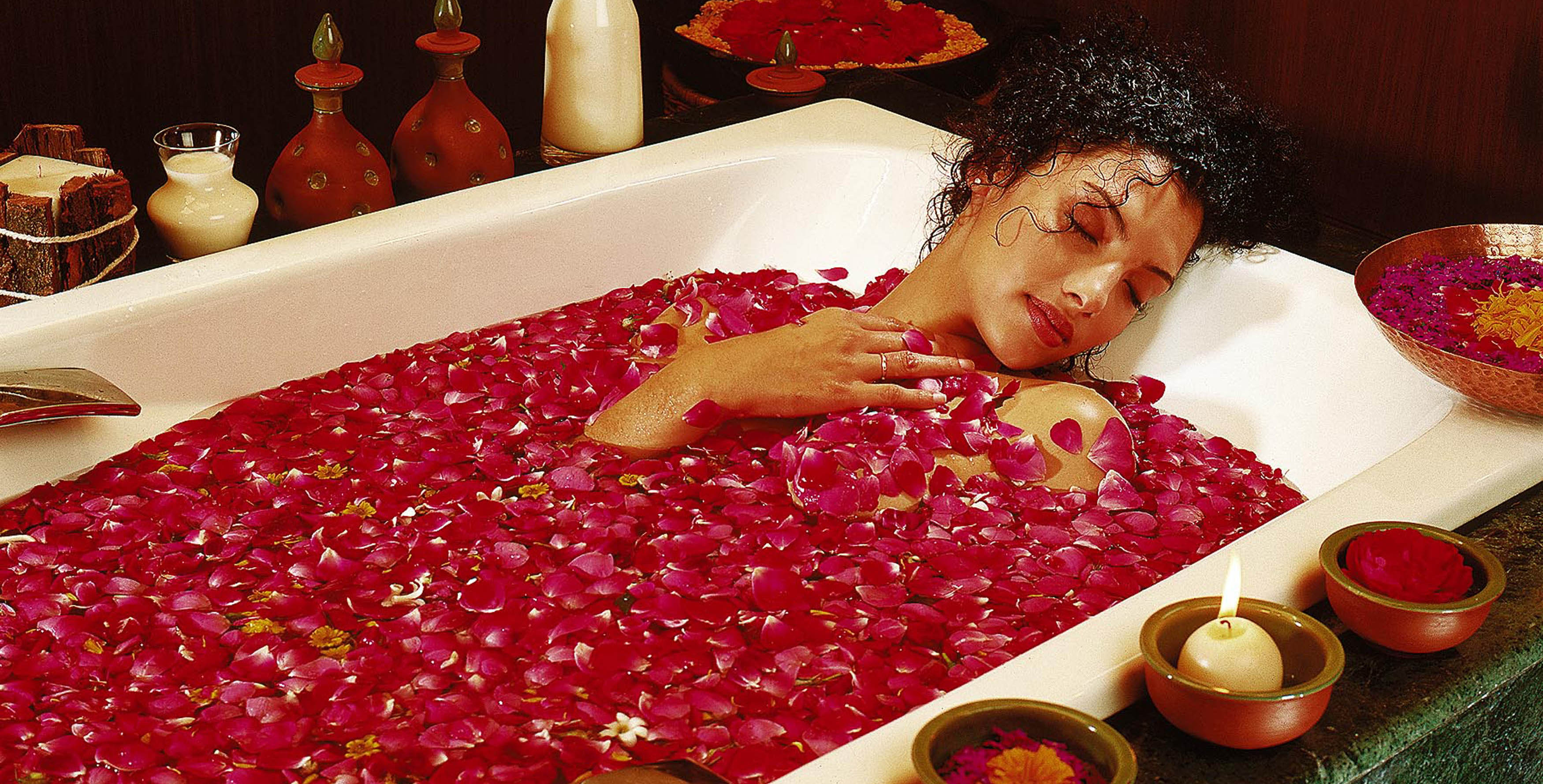 Woman enjoying a detoxifying bath in India on a detox retreat