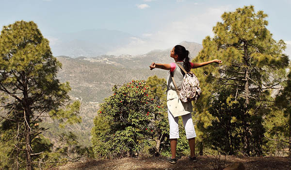 Woman hiking in the mountains around Ananda in the Himalayas, a wellness resort in India