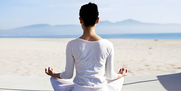 Woman practicing yoga on the Beach at TIA Wellness Resort in Vietnam