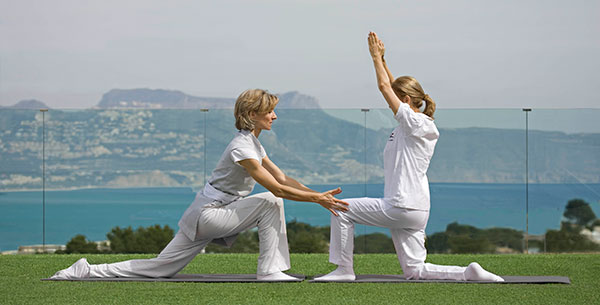 Practicing yoga at SHA Wellness Clinic with an instructor