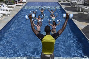 Aquafit class at the BodyHoliday in St Lucia. People train with weights in the swimming pool lead by an instructor.