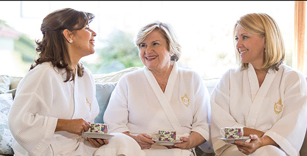 Women in dressing gowns enjoying a cup of tea