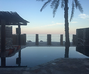 The poolside at Six Senses Zighy Bay at sunset