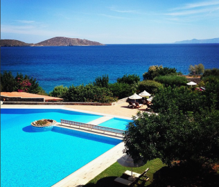 Pool area with views of Mirabello Bay at Porto Elounda Golf & Spa Resort in Crete