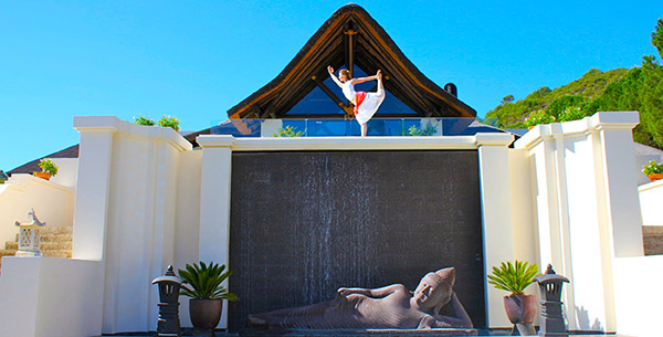 Woman doing yoga on the balcony at Shanti Som