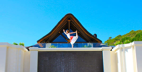 Woman doing yoga by the entrance of Shanti Som