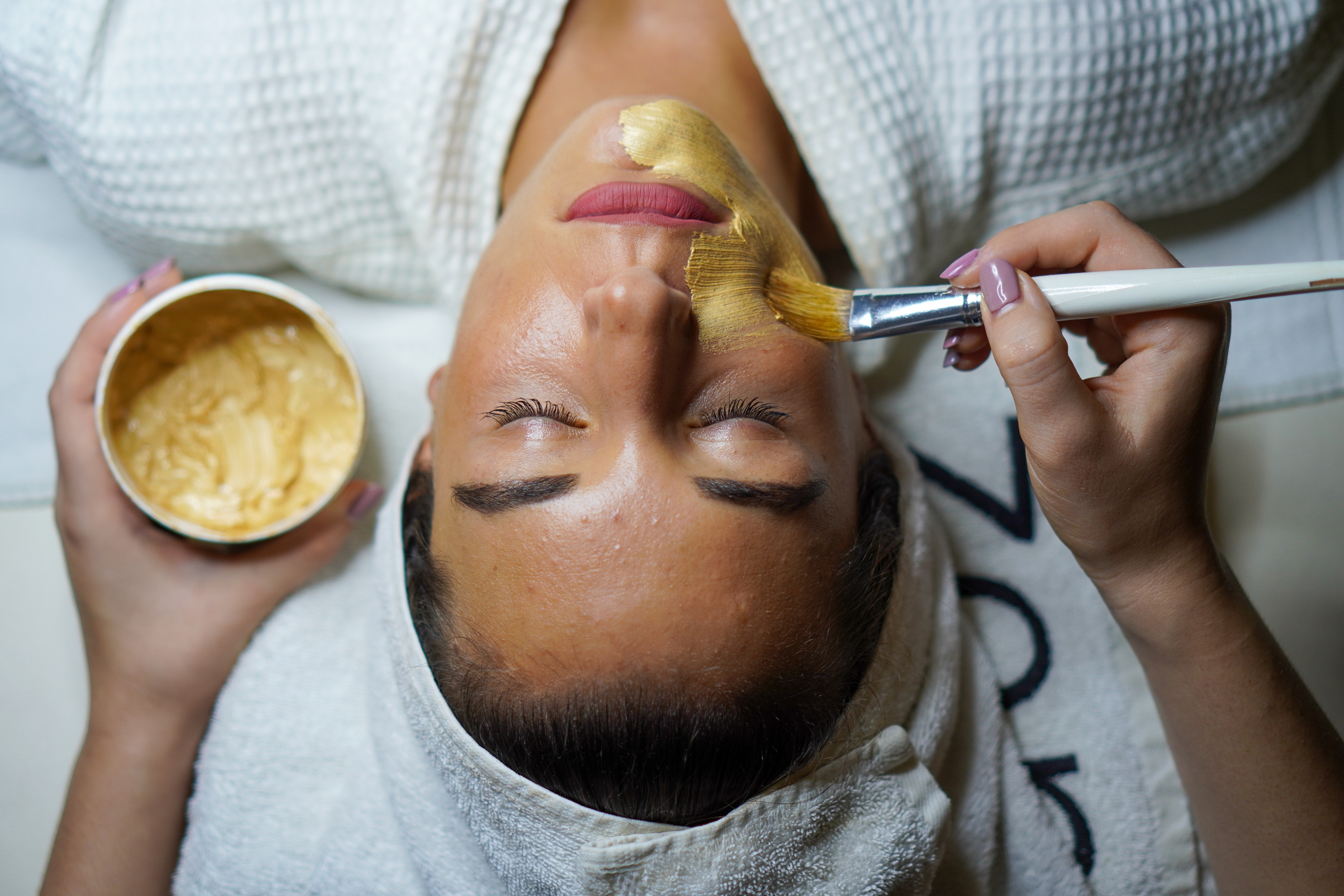 Woman having a golden mask painted on her face