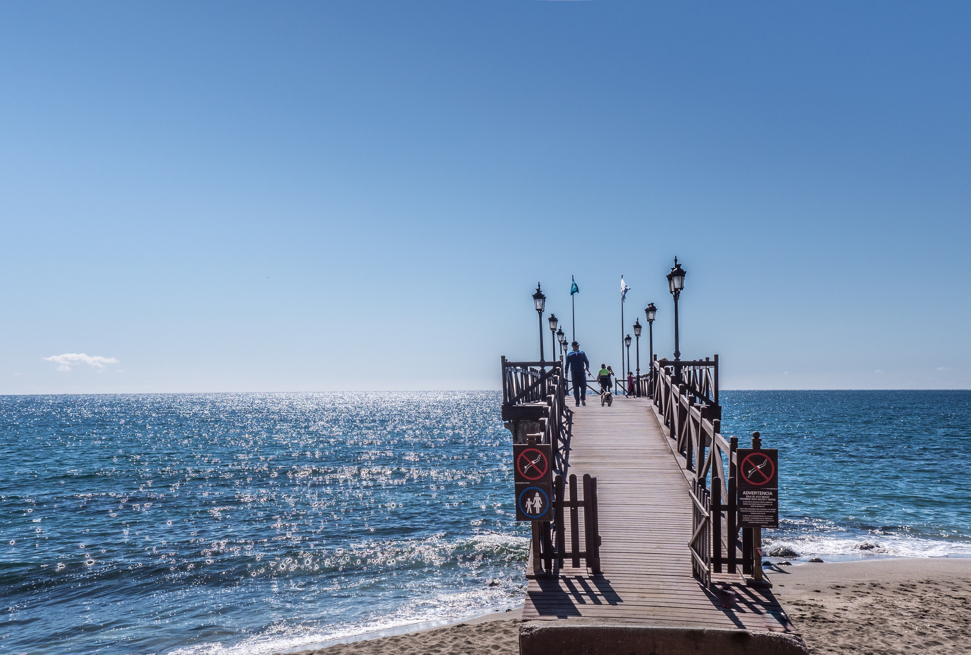 View of the sea and people walking towards