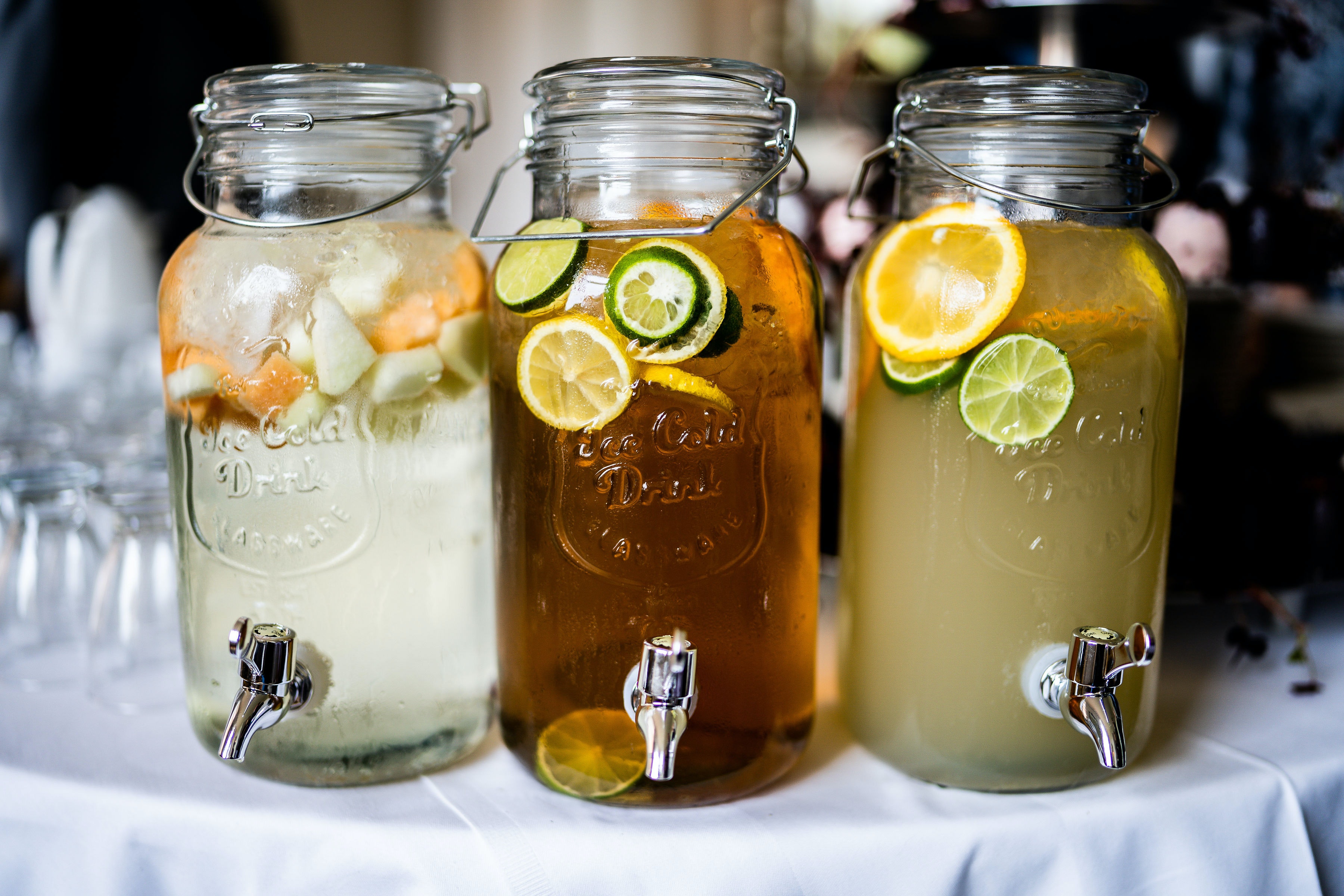 Three containers for juice with fruit in it