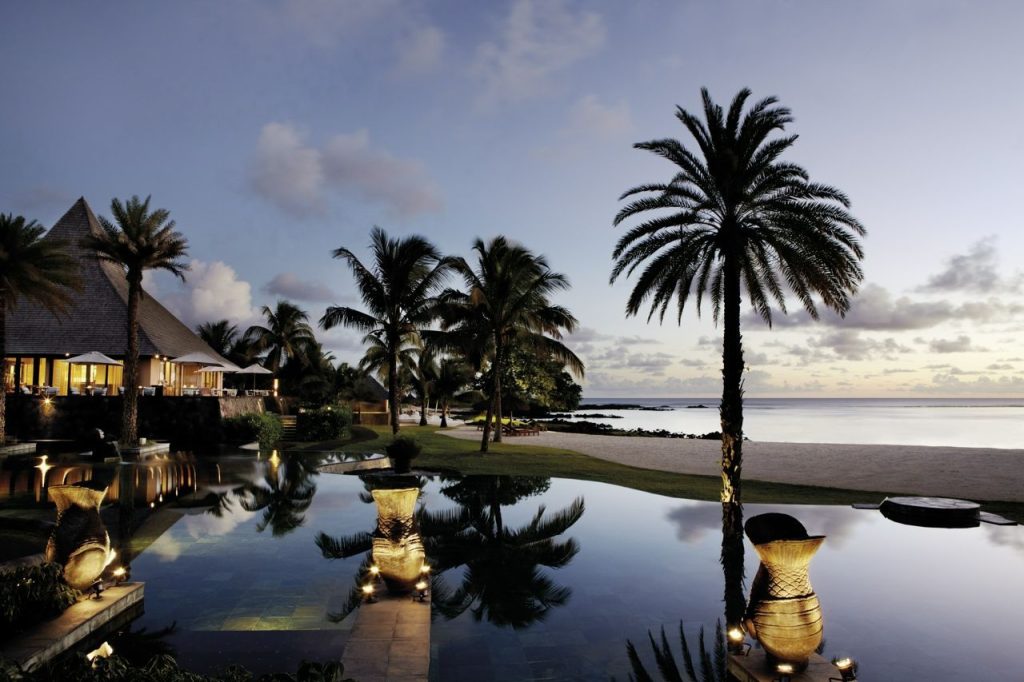 Top 10 Pilates Retreats Around the World Pool and palm trees at Shanti Maurice Resort and Spa in Mauritius