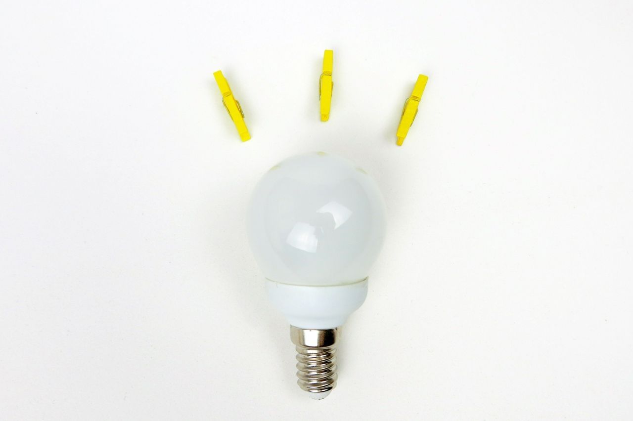 lightbulb with yellow pegs placed closeby to give the illusion of power or an idea being formed.
