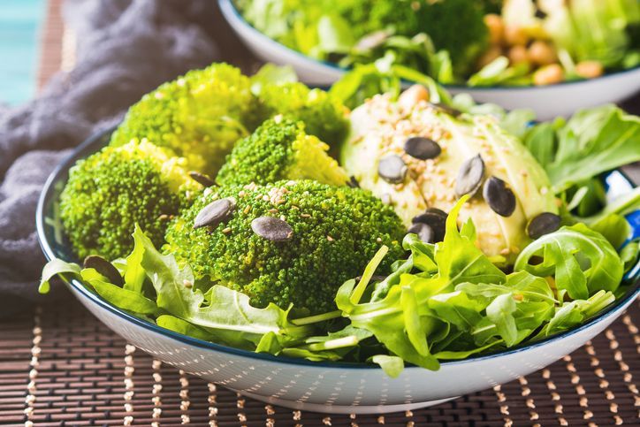 Green plant based salad with broccoli and avocado, arugula, pumpkin seeds, chickpeas. Vegan lunch bowl.