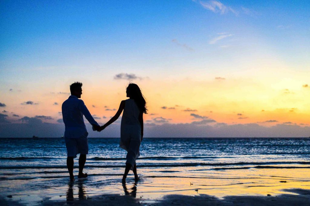 Man and woman lie relaxed looking upwards as they bathe in a turquoise swimming pool