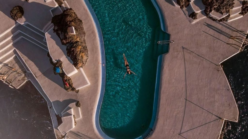 Woman swimming in a pool, relaxed on holiday