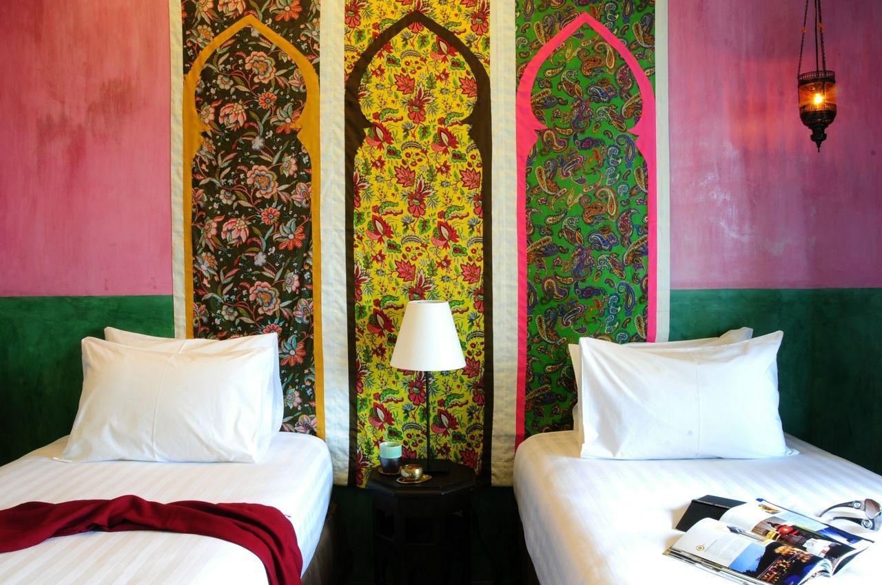 Two single beds in a colourful room