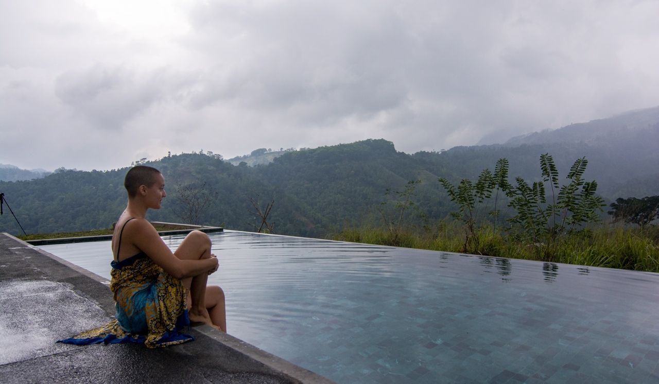 Woman sitting by the pool at Santani Wellness Resort & Spa